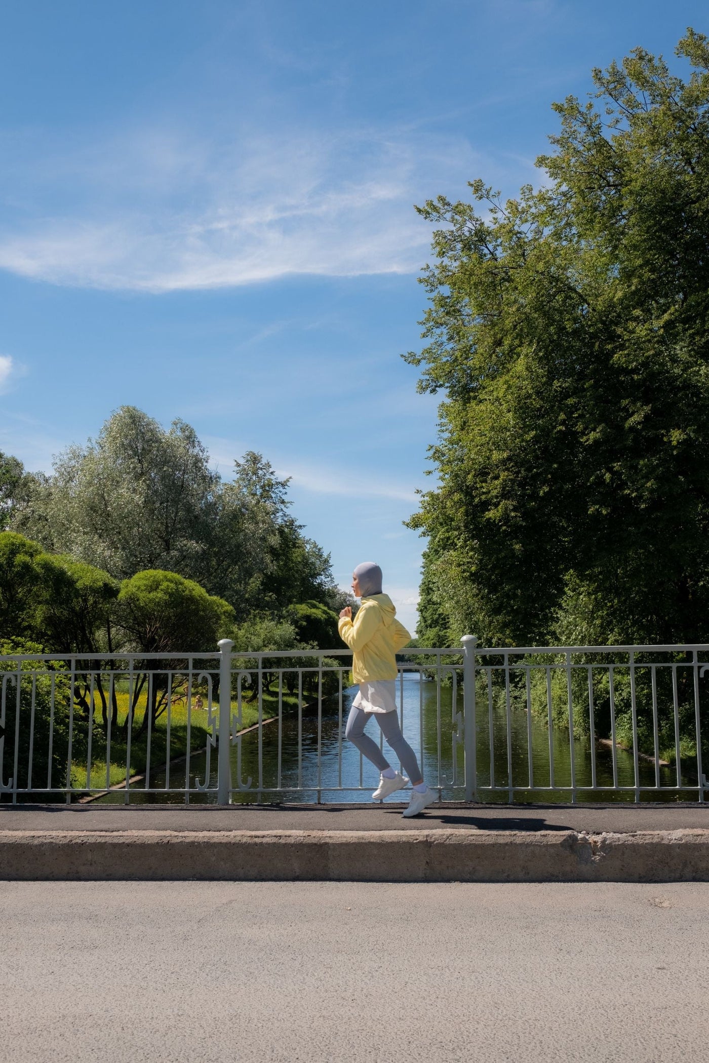 Muslim woman wearing modest sportswear and a hijab while jogging outdoors, illustrating secure active clothing, movement and performance