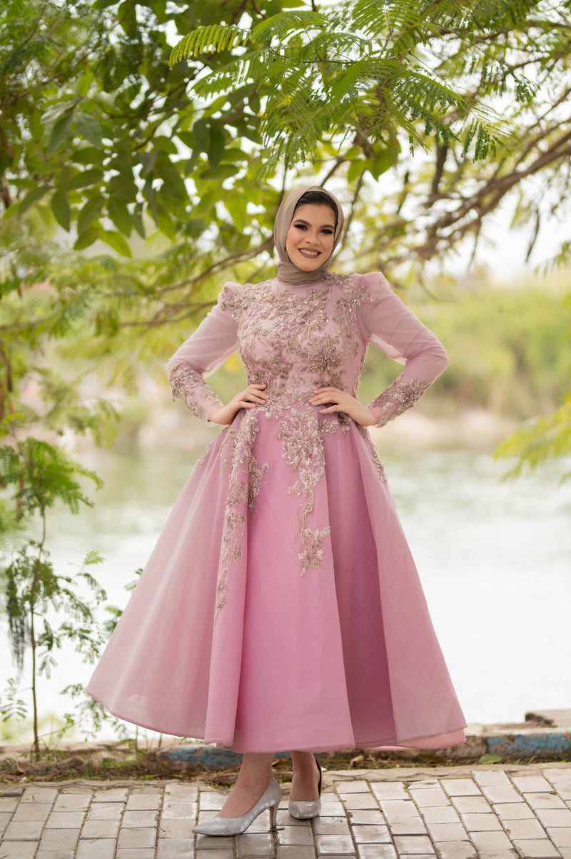 Muslim woman wearing a flowing pink modest dress and hijab outdoors, illustrating blush, dusty and formal pink dress styling