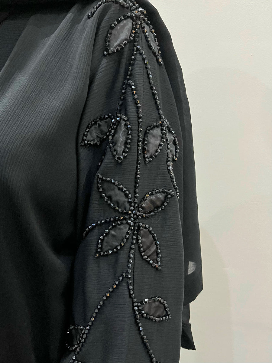 Close-up of the black leaf beadwork on the textured abaya