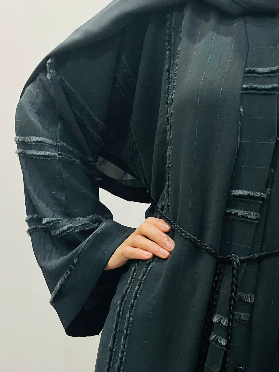 Black open abaya styled open as a flowing layer over an outfit