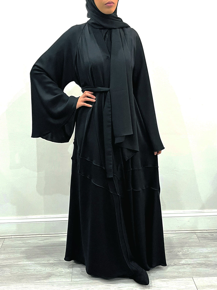 Amani's black umbrella-cut open abaya showing the wide flared hem