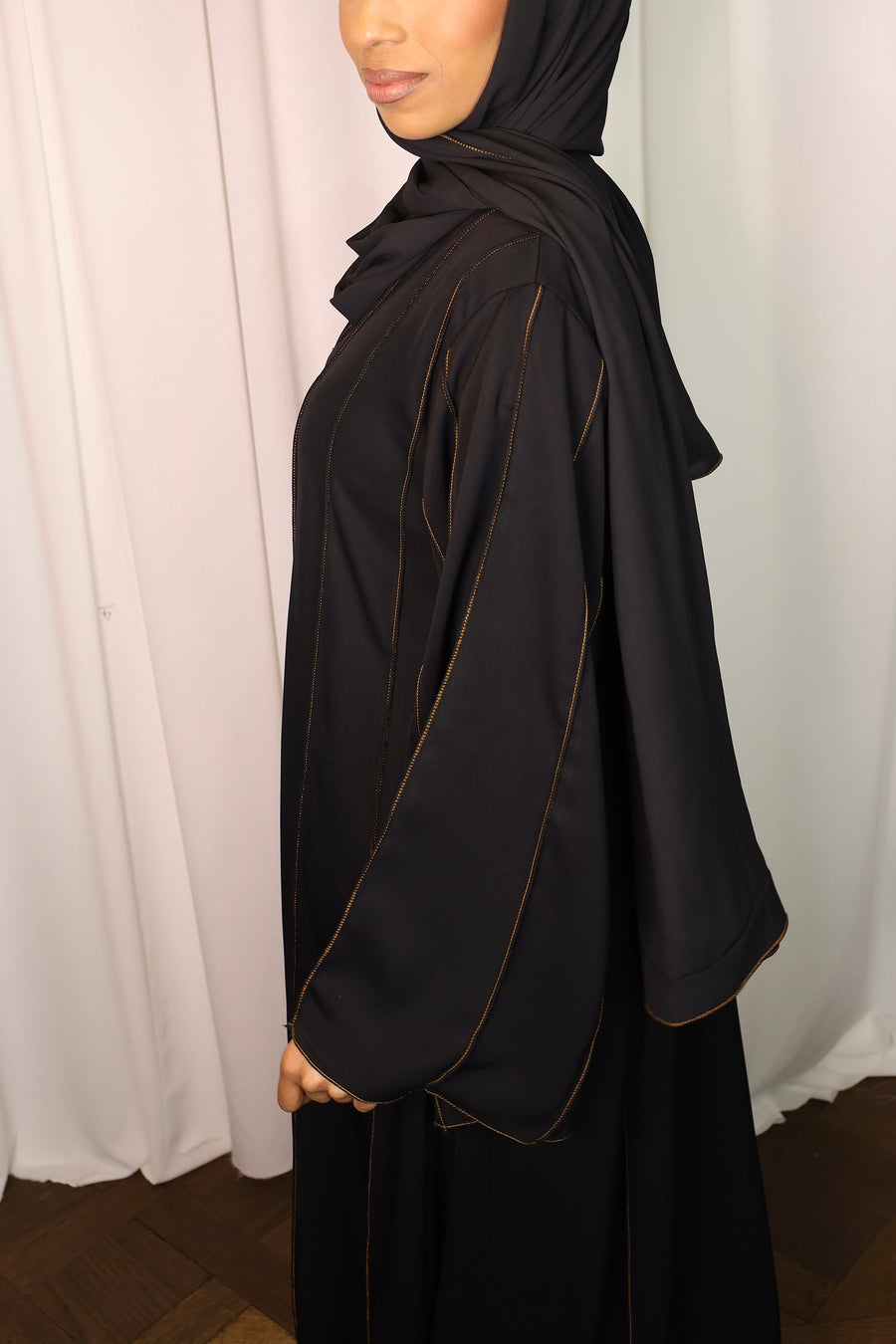 Burnt orange piped abaya showing the Neda fabric drape