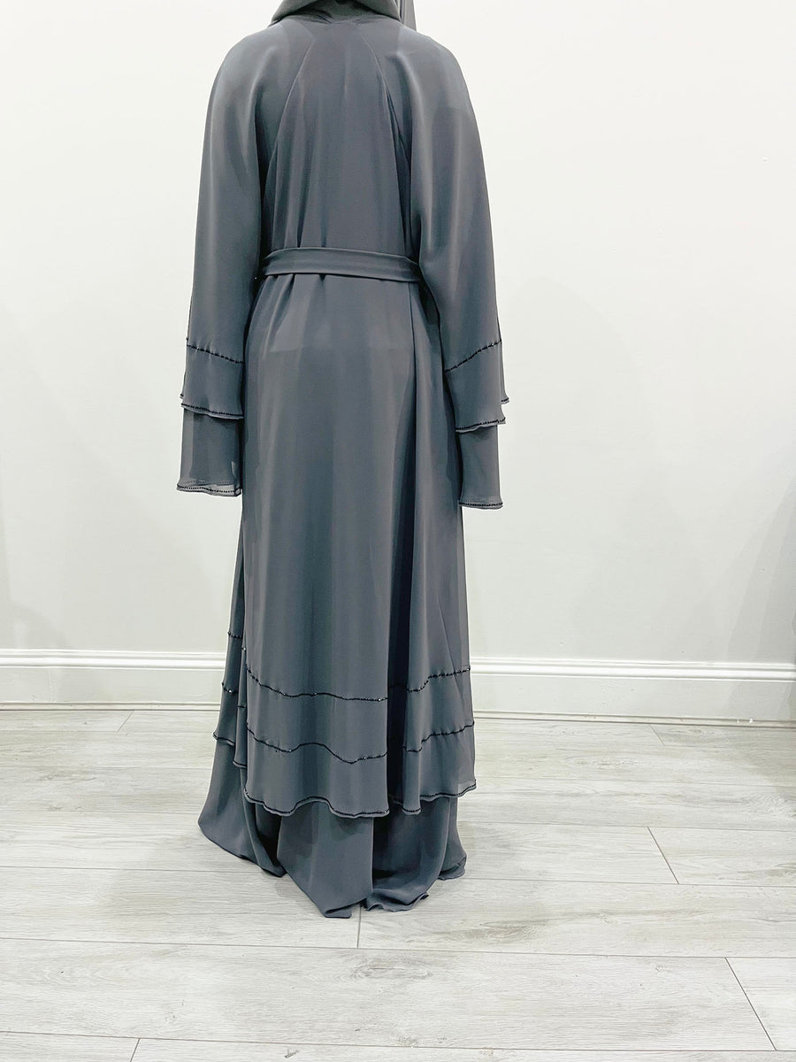 Grey chiffon abaya belted at the waist showing the layered drape