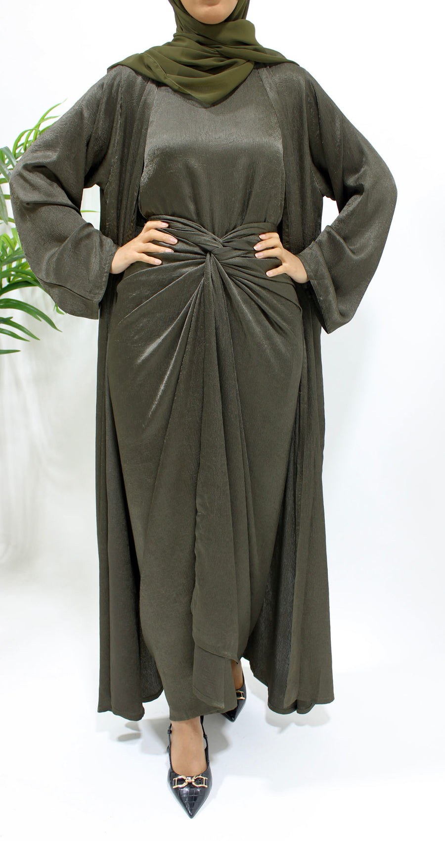 Side view of the army green crushed satin open abaya showing its calm earthy sheen