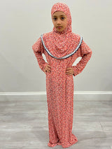 Little girl wearing Amani's coral one-piece slip-on prayer dress with attached hijab