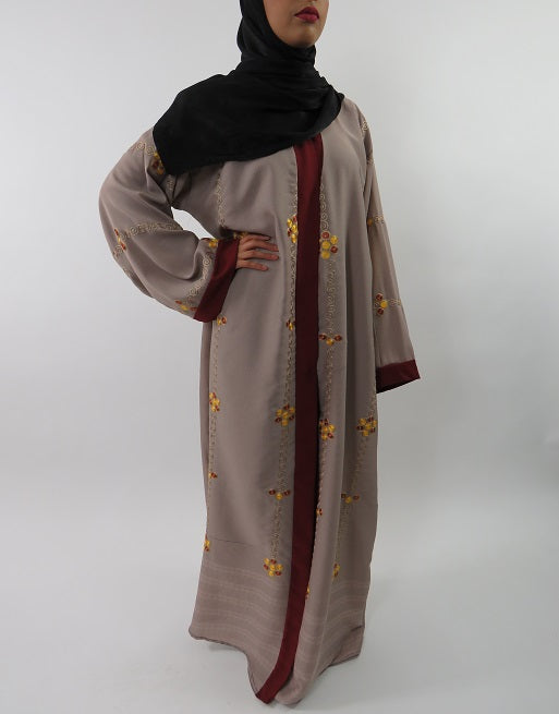 Close view of the golden swirl embroidery on the burgundy open abaya