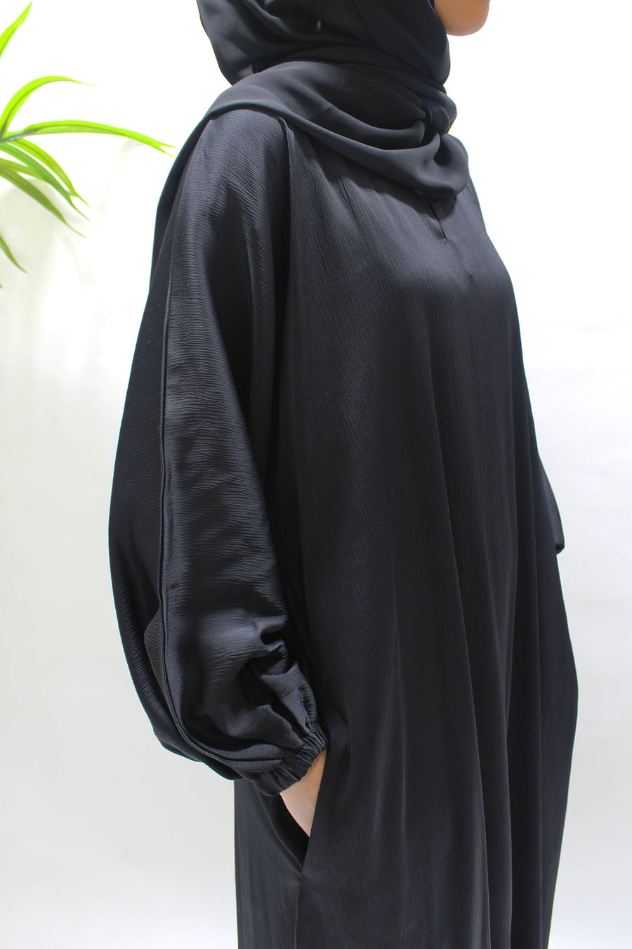 Textured satin fabric detail on the black abaya