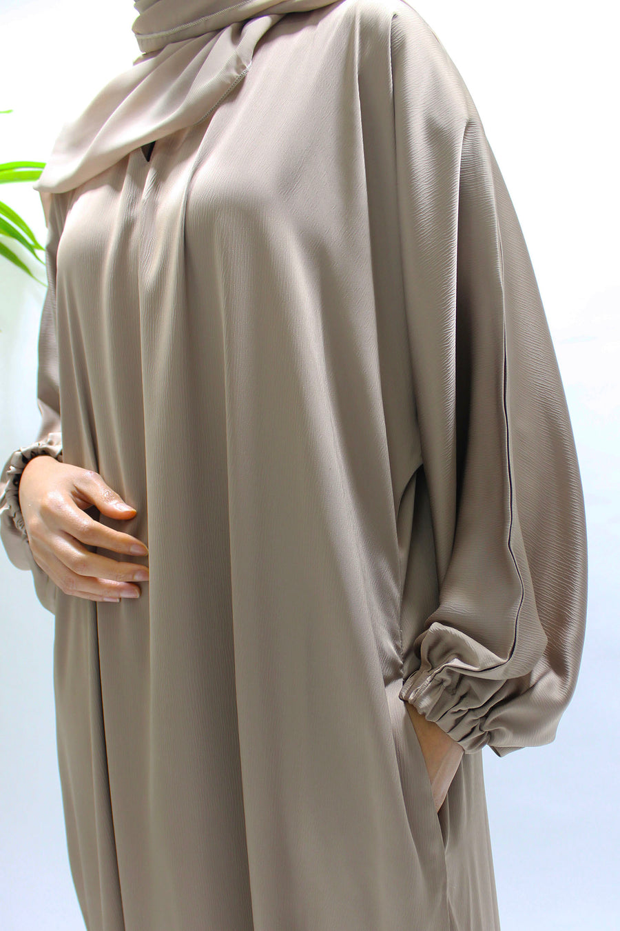 Side pocket on the dark beige textured satin abaya