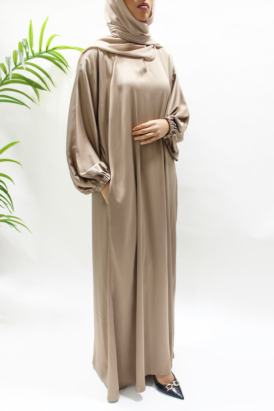 Textured satin fabric detail on the dark beige abaya