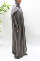 Woman wearing Amani's dark taupe textured satin abaya with matching hijab