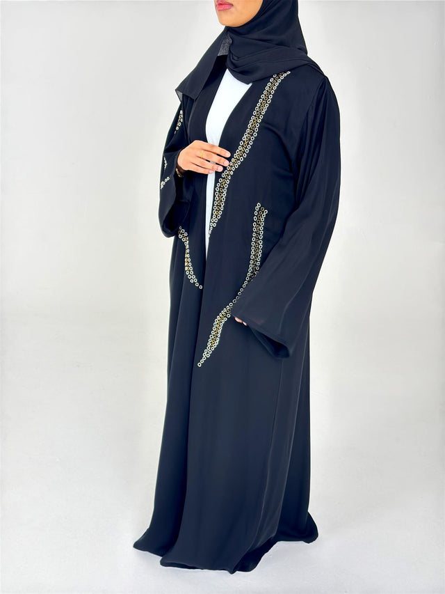 Woman wearing Amani's embellished black duster style abaya with scarf