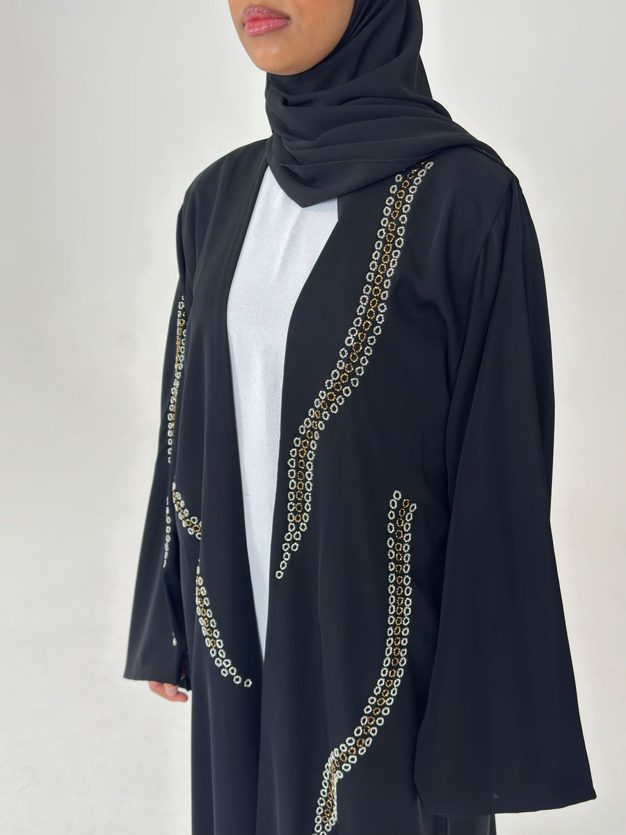 Fluid drape of the black embellished duster abaya