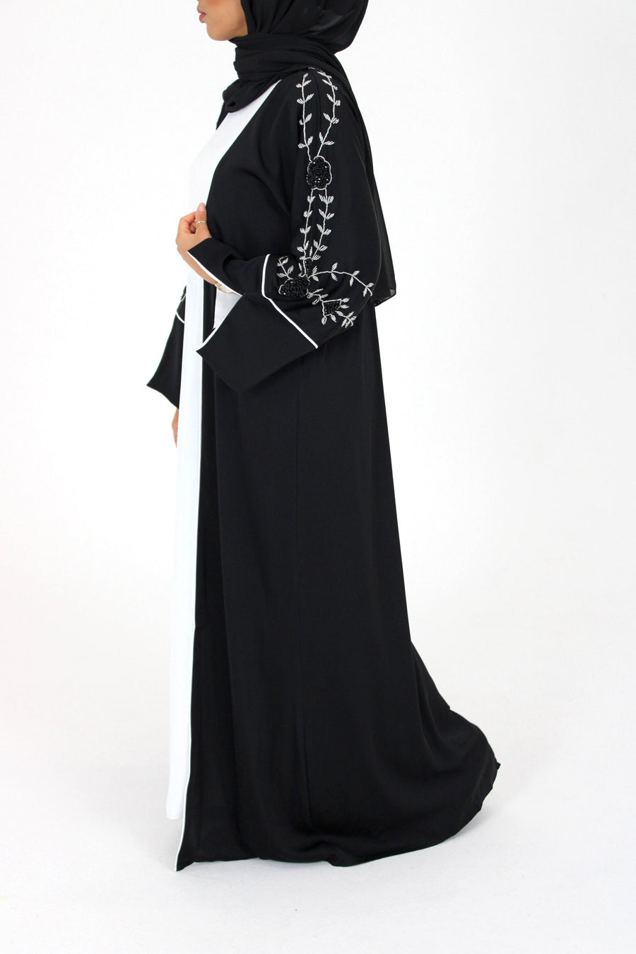 Black open abaya over the white inner slip dress