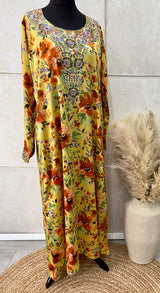 Woman wearing Amani's orange floral mukhawar dress with matching scarf