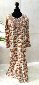 Little girl wearing Amani's ocher orange floral mukhawar dress