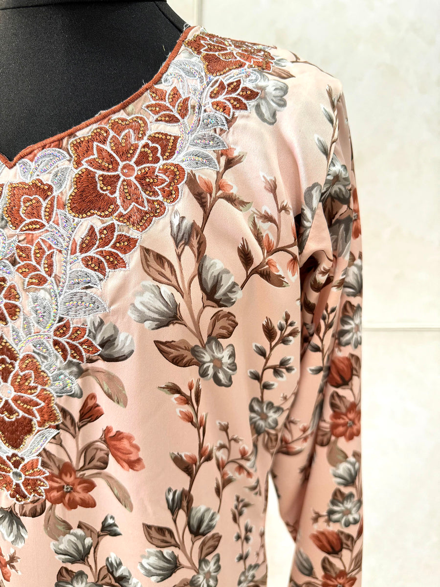 Full-length view of Amani's soft peach floral mukhawar dress
