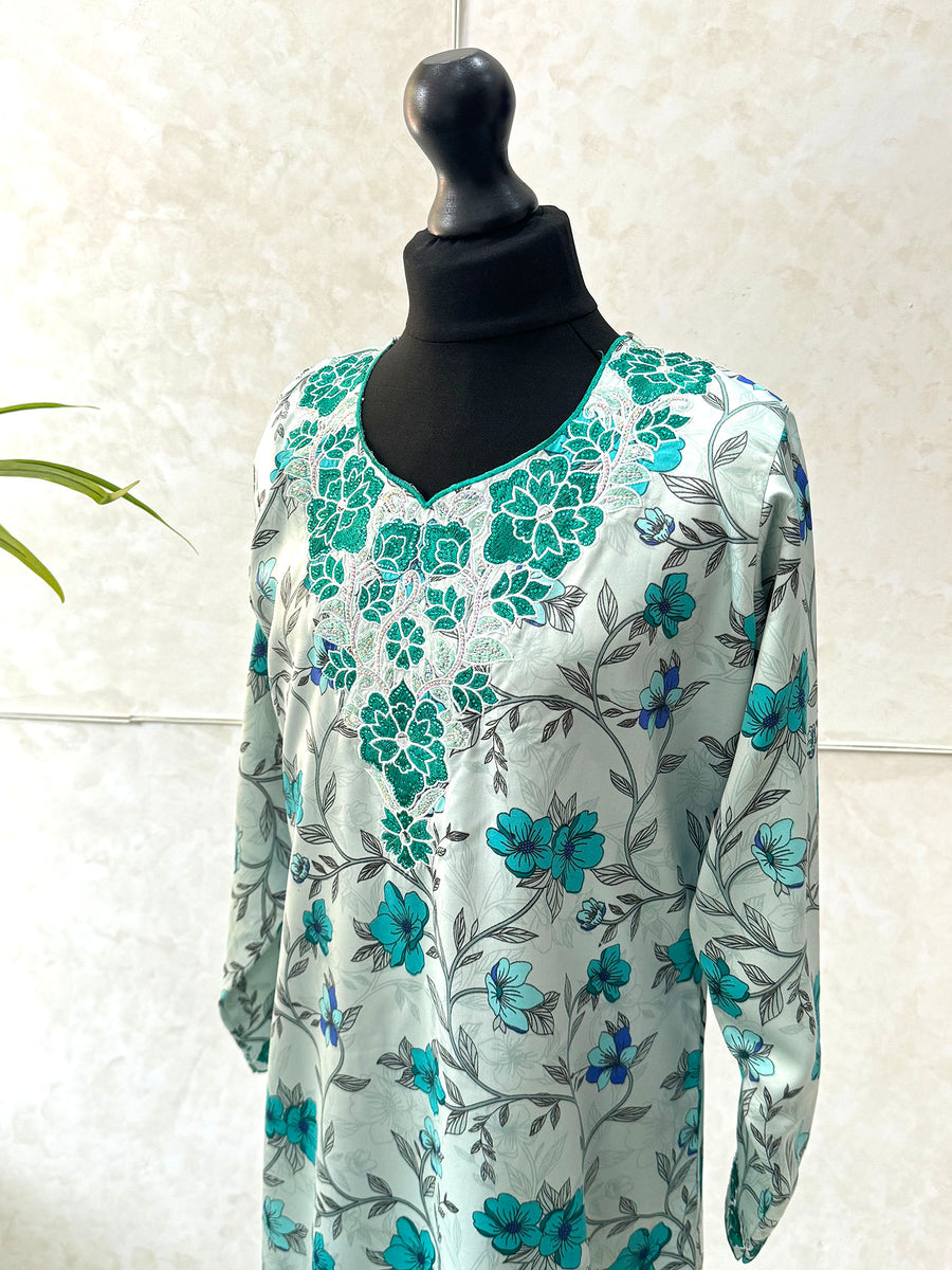 Little girl wearing Amani's turquoise floral mukhawar dress