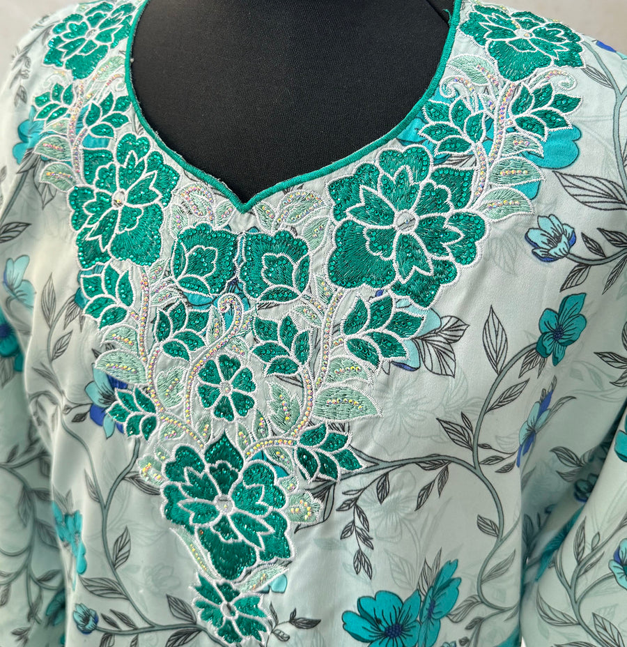 Full-length view of Amani's turquoise floral mukhawar dress