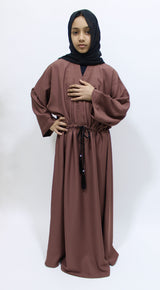 Girl wearing Amani's dark blush draw string abaya with matching scarf