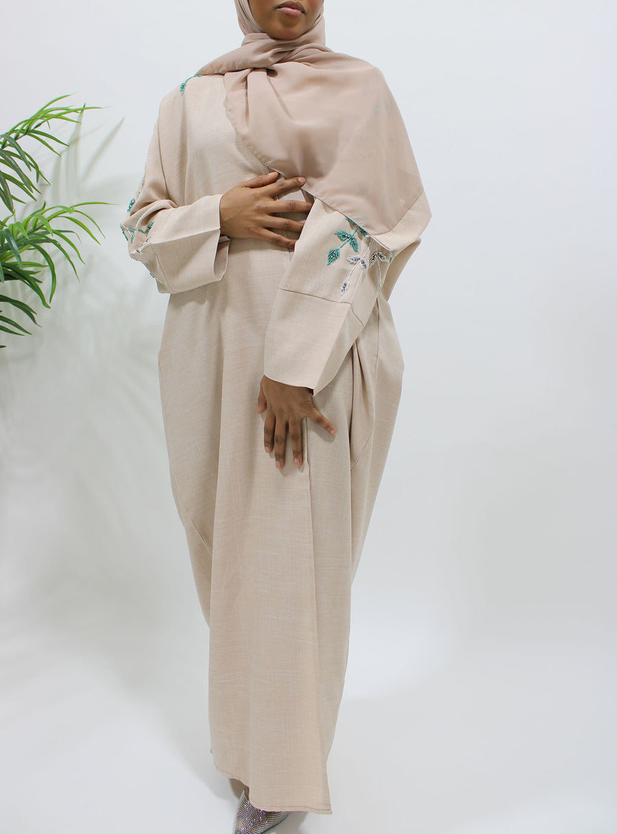Hand-stitched sleeve embellishment on Amani's nude linen bisht abaya