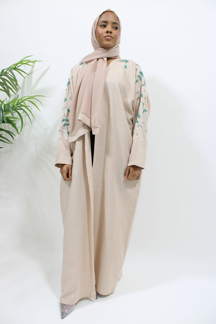 Side view of the nude linen blend bisht abaya showing its relaxed bisht cut