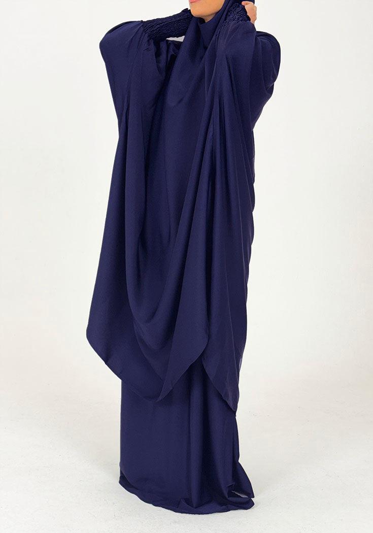 Navy blue jilbab set showing flowing overhead drape, side view