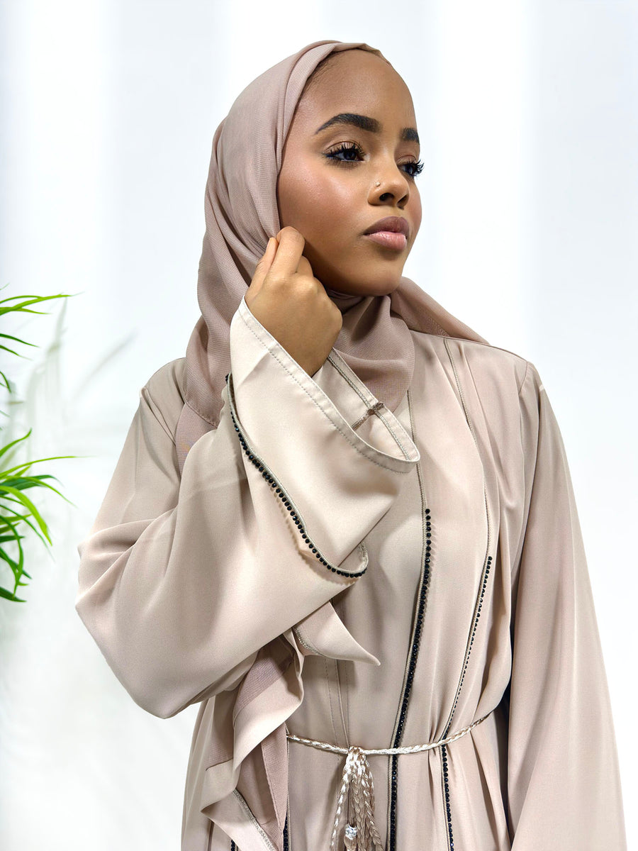 Close view of the black embellished piping on the nude open abaya