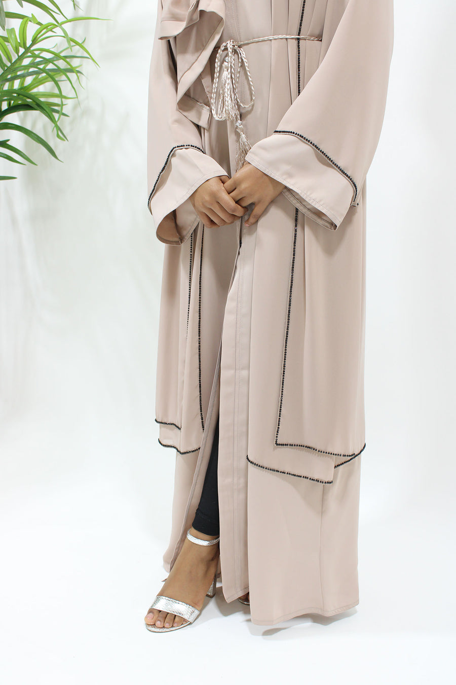 Side view of the nude open abaya showing its layered drape