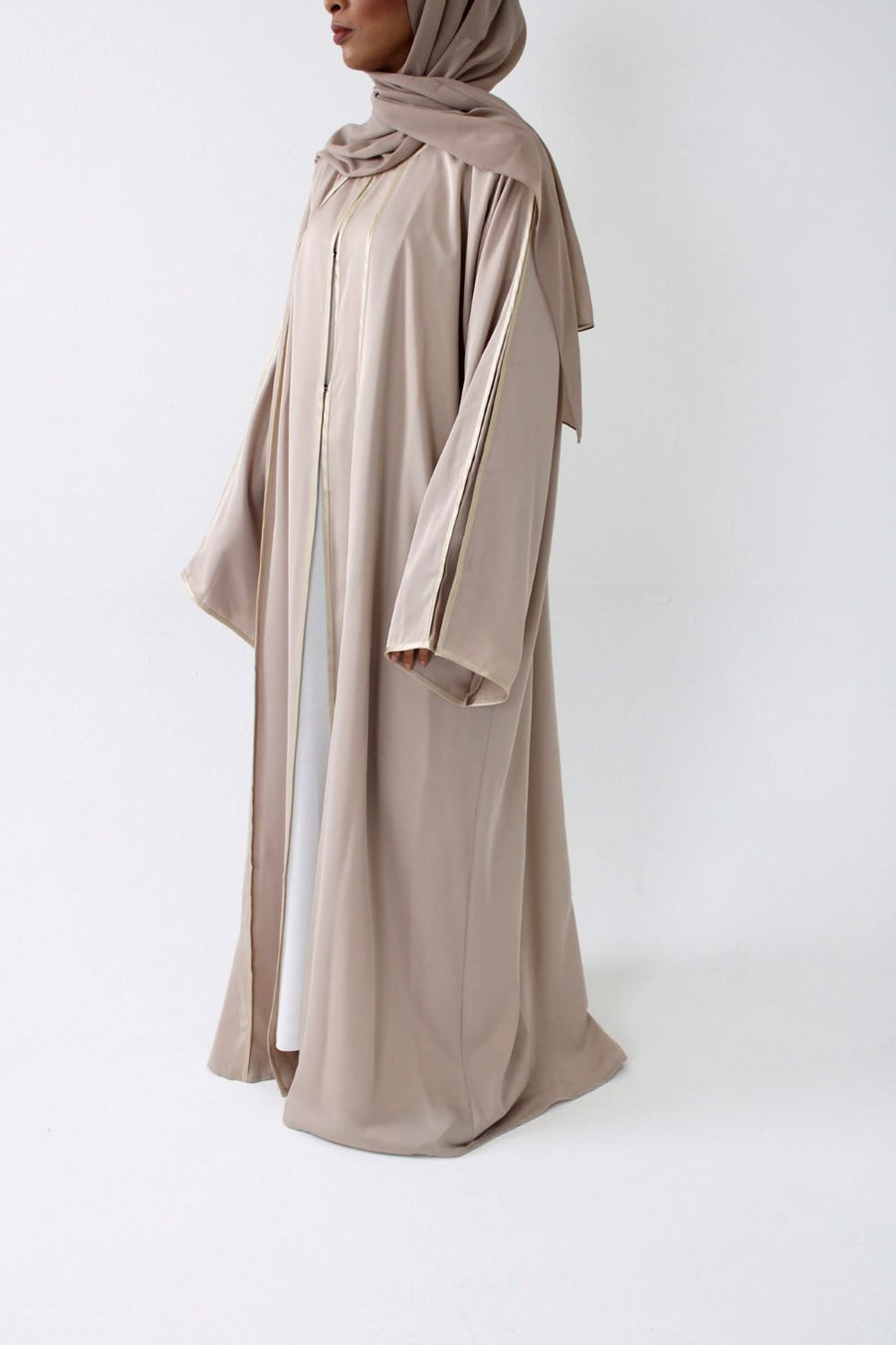 Beige open abaya layered over an inner dress