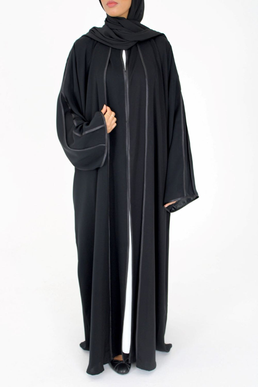 Satin piping edge detail on the black open abaya