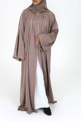 Woman wearing Amani's rose taupe open abaya with satin piping and scarf