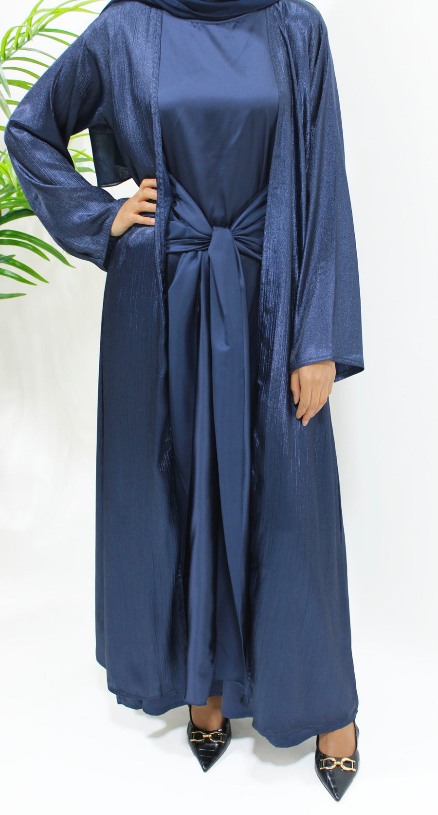 Side view of the navy shimmer open jacket abaya layered over the inner dress