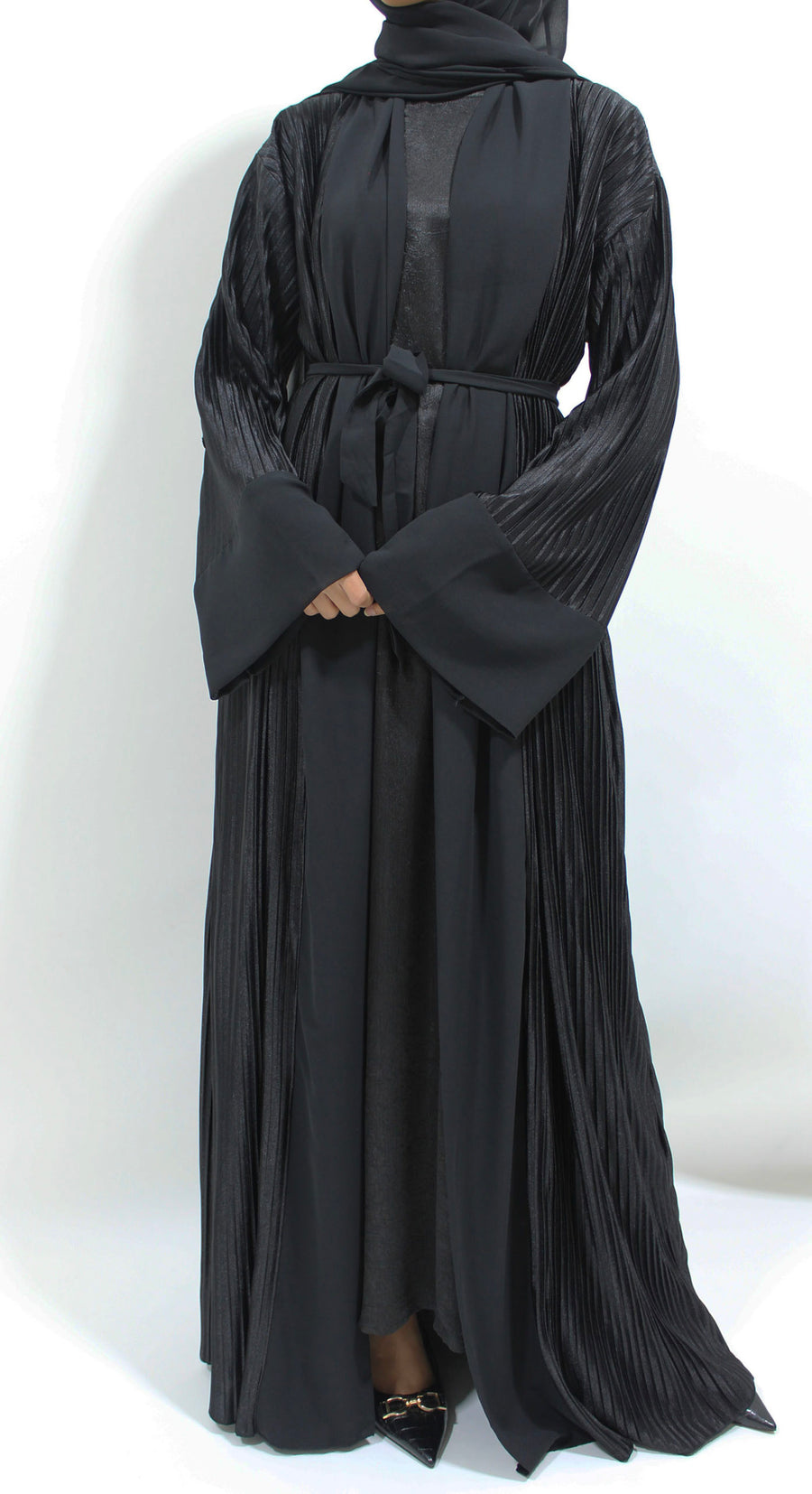 Side view of the black pleated satin open abaya showing the vertical pleats