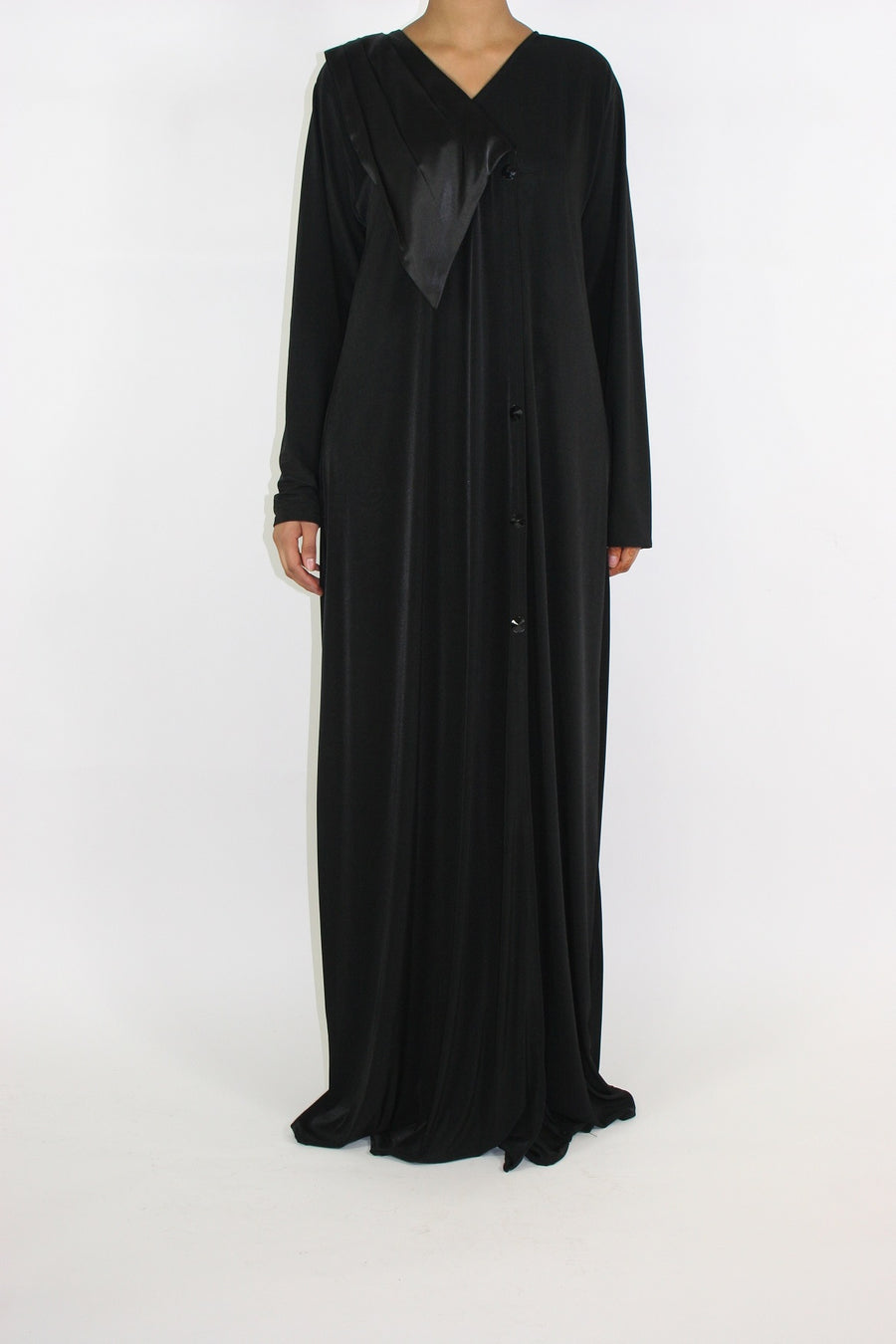 Close view of the button closure and satin flap on the black and burgundy abaya