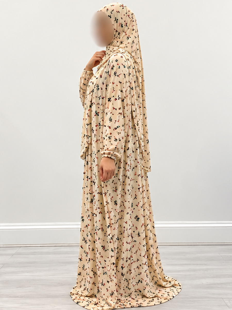 Side profile of Amani's buttermilk cream floral prayer dress showing the attached wrap-around hijab, modest full-length drape and elasticated wrists without lace