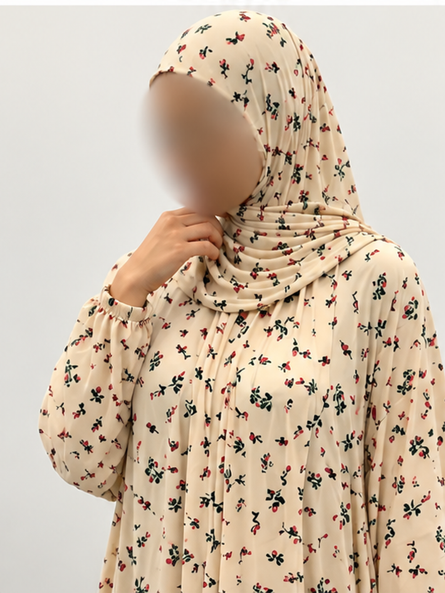 Close-up of Amani's buttermilk floral one-piece prayer dress, plain lace-free attached wrap-around hijab edge, delicate red and green print and thin elastic wrist cuff