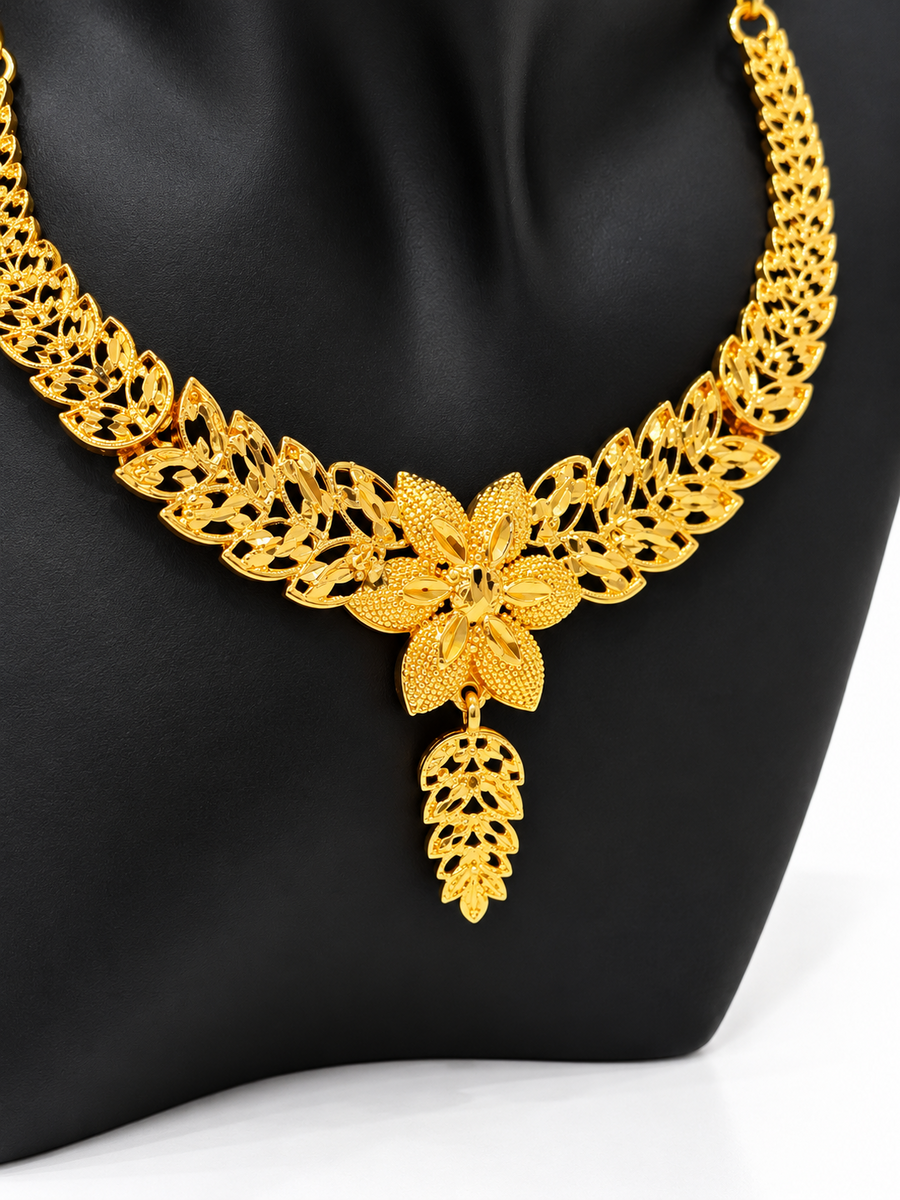 Close-up of golden floral necklace with layered leaf detailing