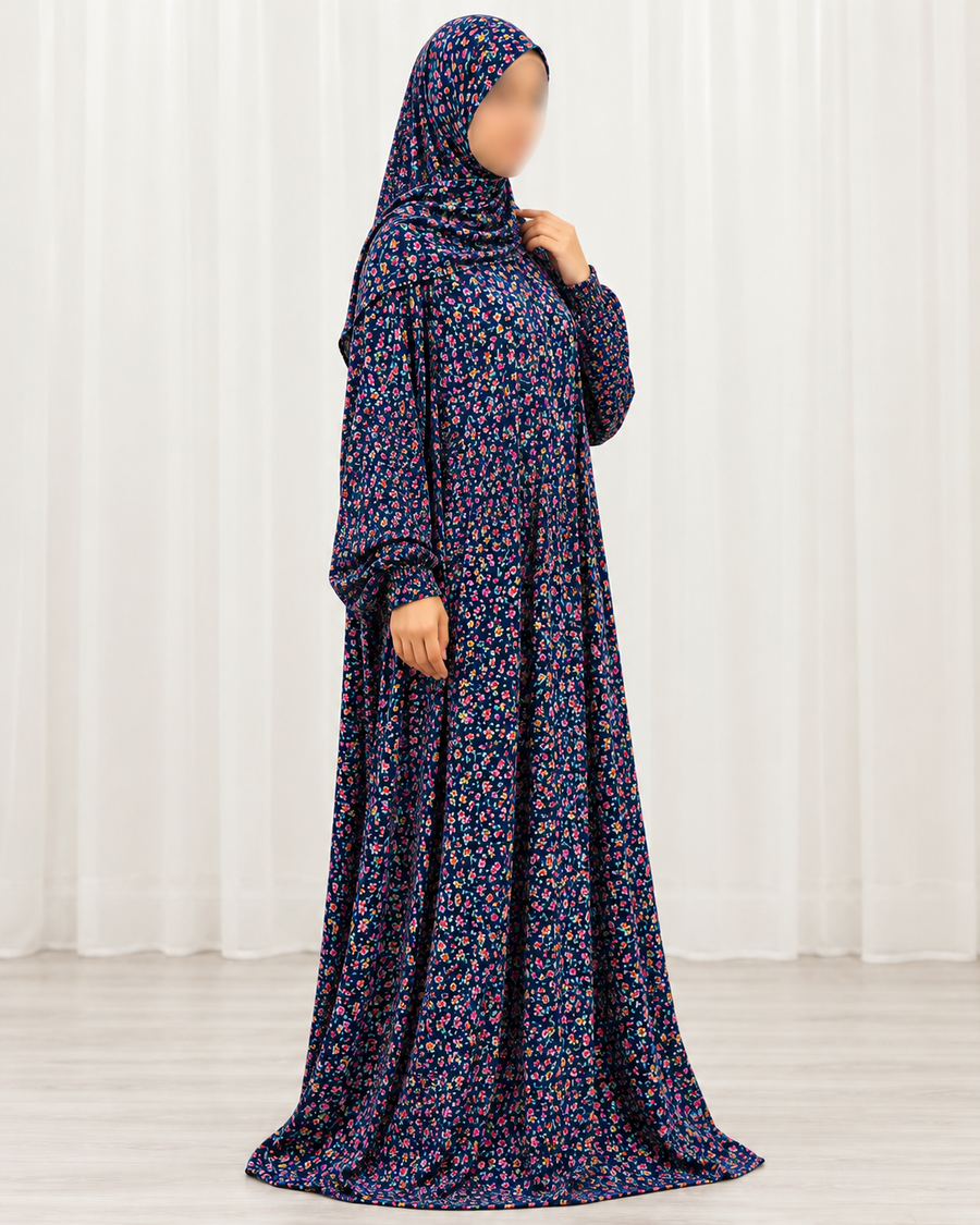 Amani's navy mini floral prayer dress with matching attached hijab, three-quarter view with sleeves falling naturally, no lace