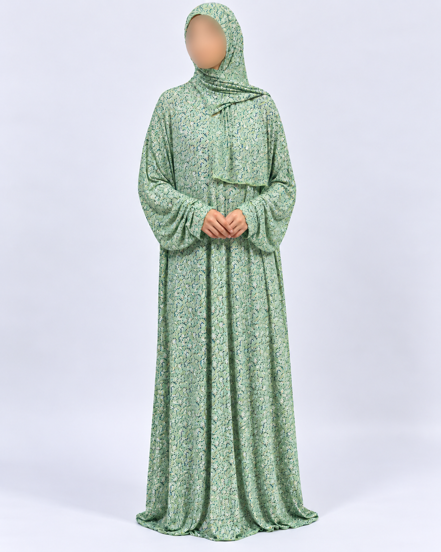 Amani's soft green micro-floral one-piece prayer dress with attached hijab, full front view with sleeves down and plain lace-free edges