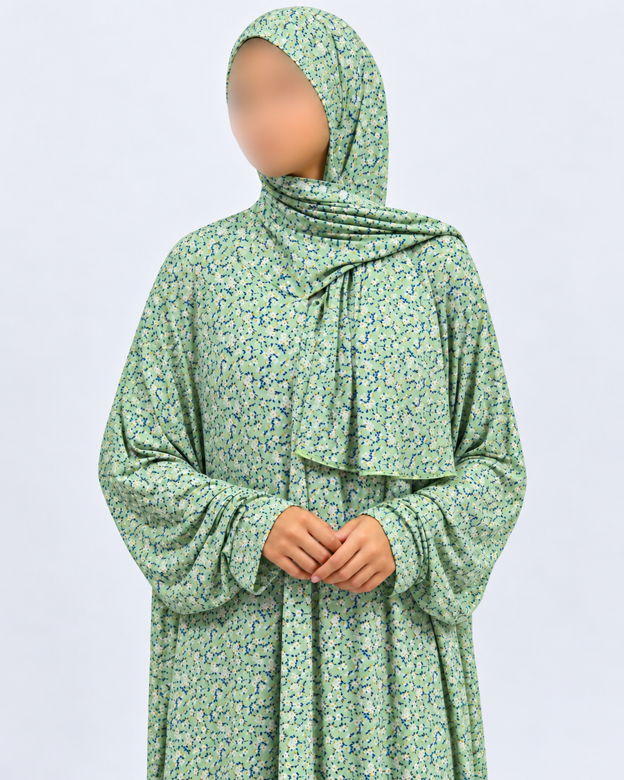Upper-body detail of the soft green prayer dress showing the matching attached hijab, micro-floral fabric and plain cuffs without lace