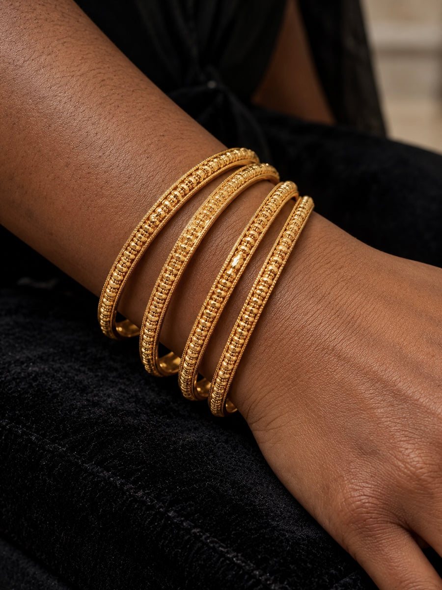 Gold beaded-link bangles set of 4 worn on the wrist