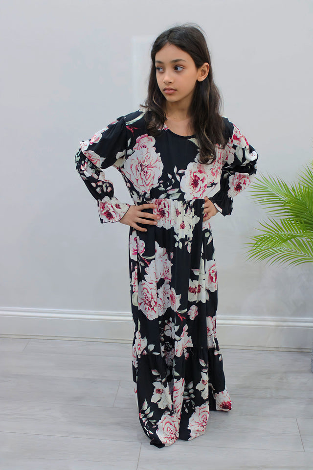 Girl wearing Amani's black puff-sleeve tiered dress