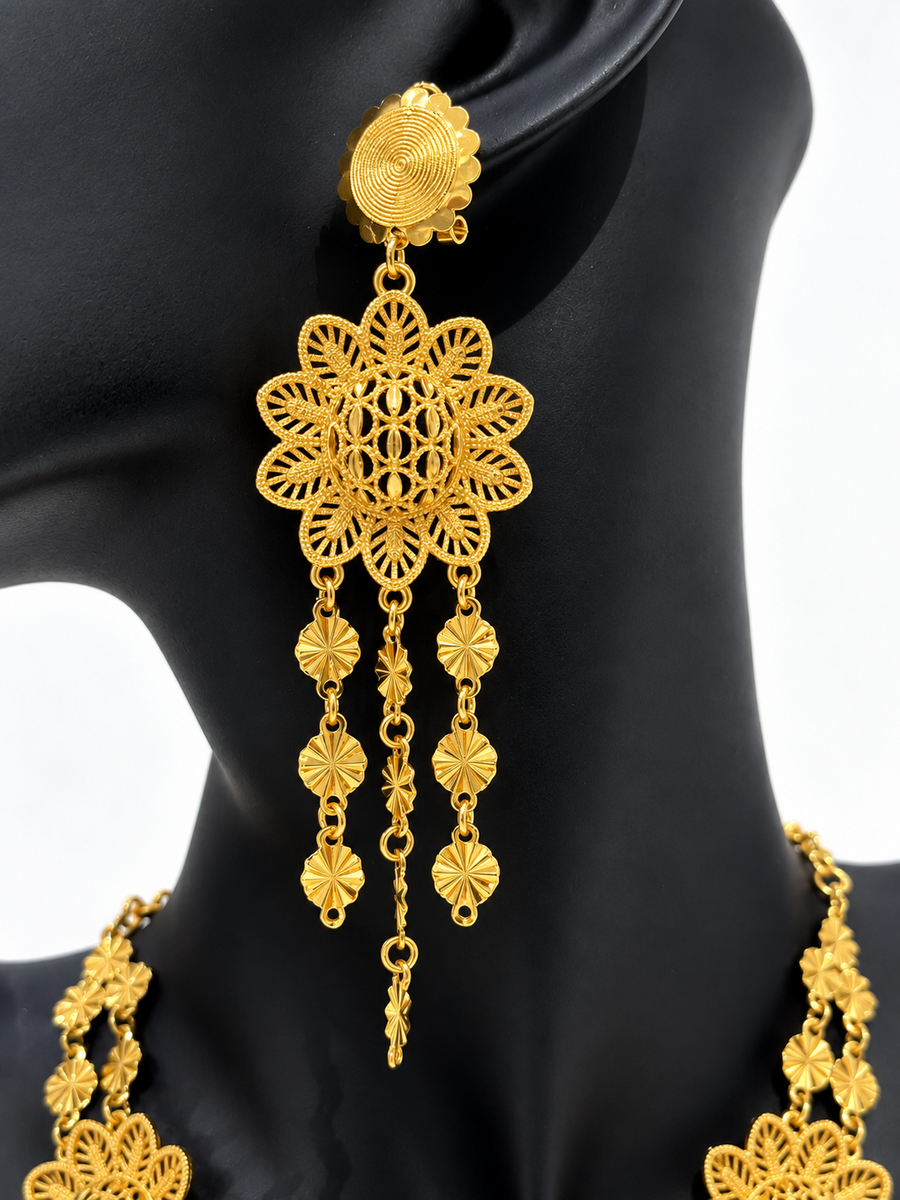 Close-up of gold-tone sunburst medallion drop earring