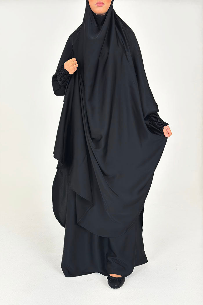 Black two-piece jilbab set with an overhead head covering and maxi skirt, one example of full-body modest clothing