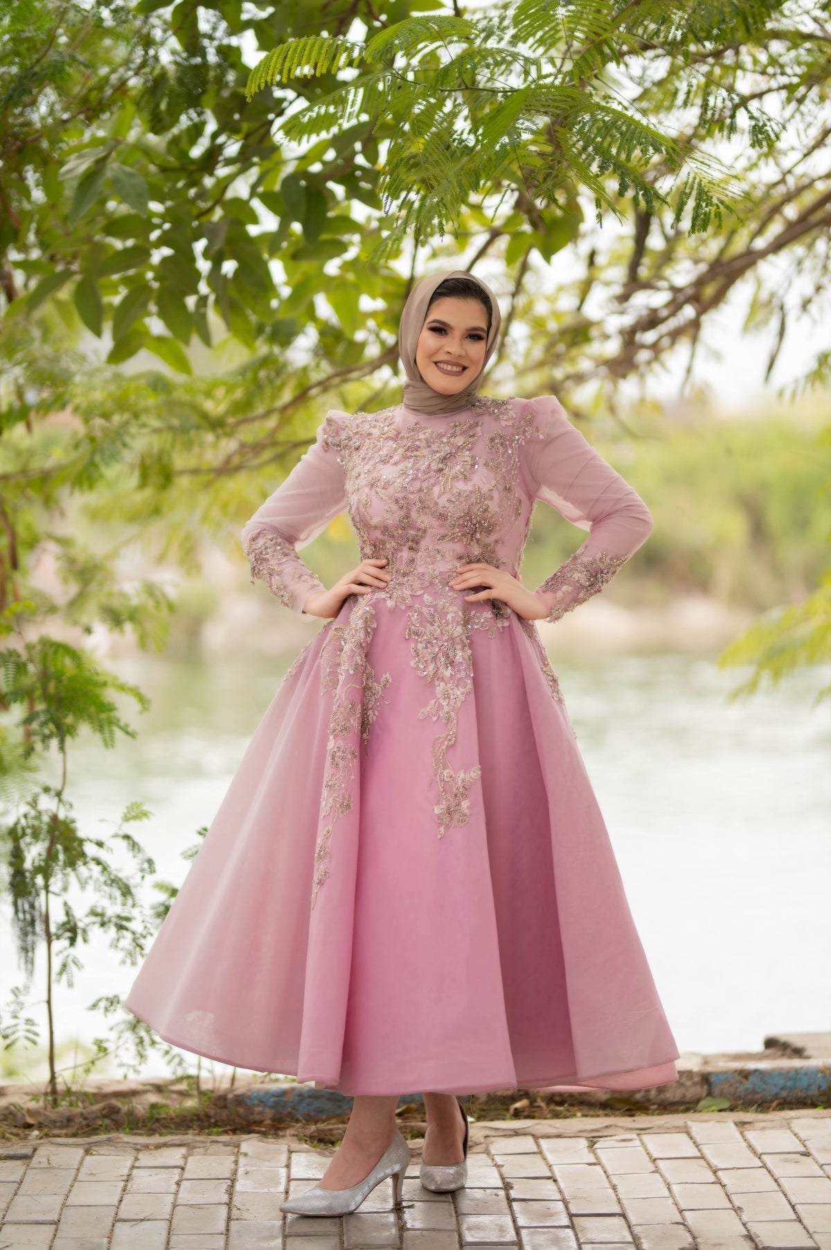 Muslim woman wearing a flowing pink modest dress and hijab outdoors, illustrating blush, dusty and formal pink dress styling