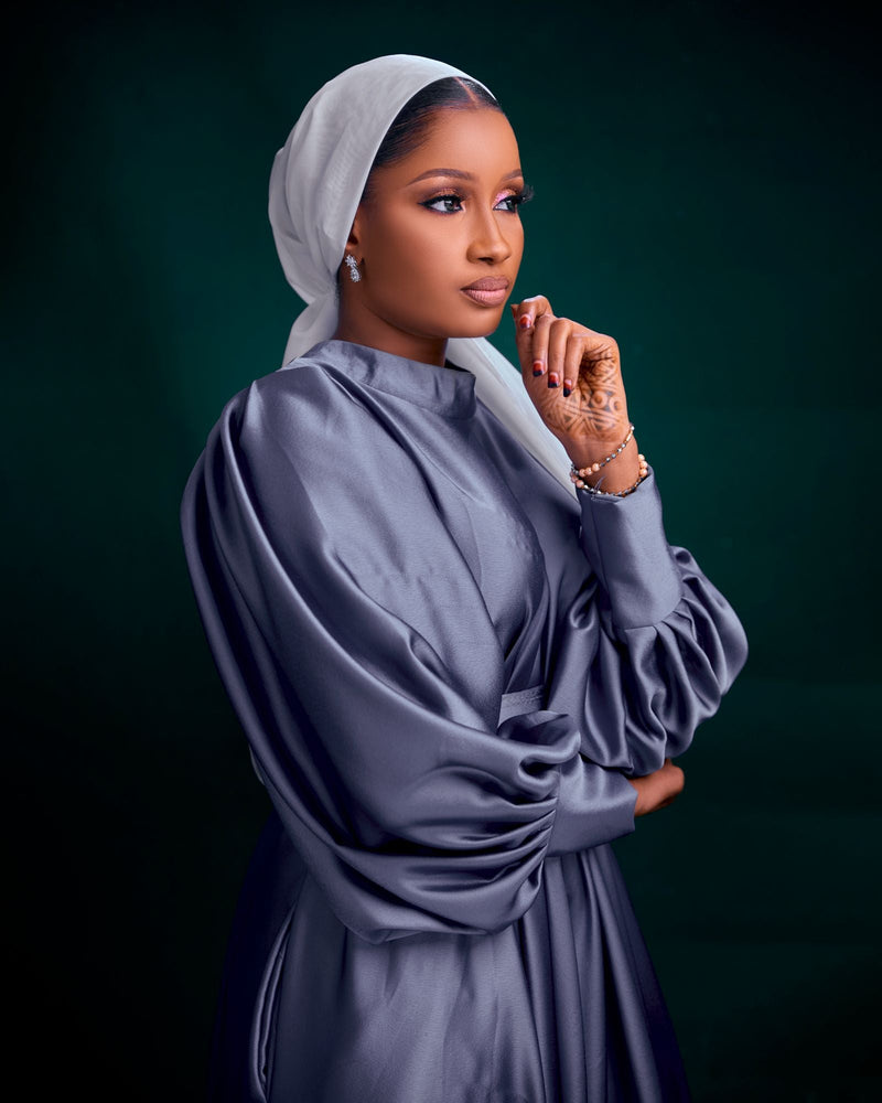 Muslim woman wearing an elegant navy blue formal gown and hijab, illustrating modest navy lace, prom and evening styling