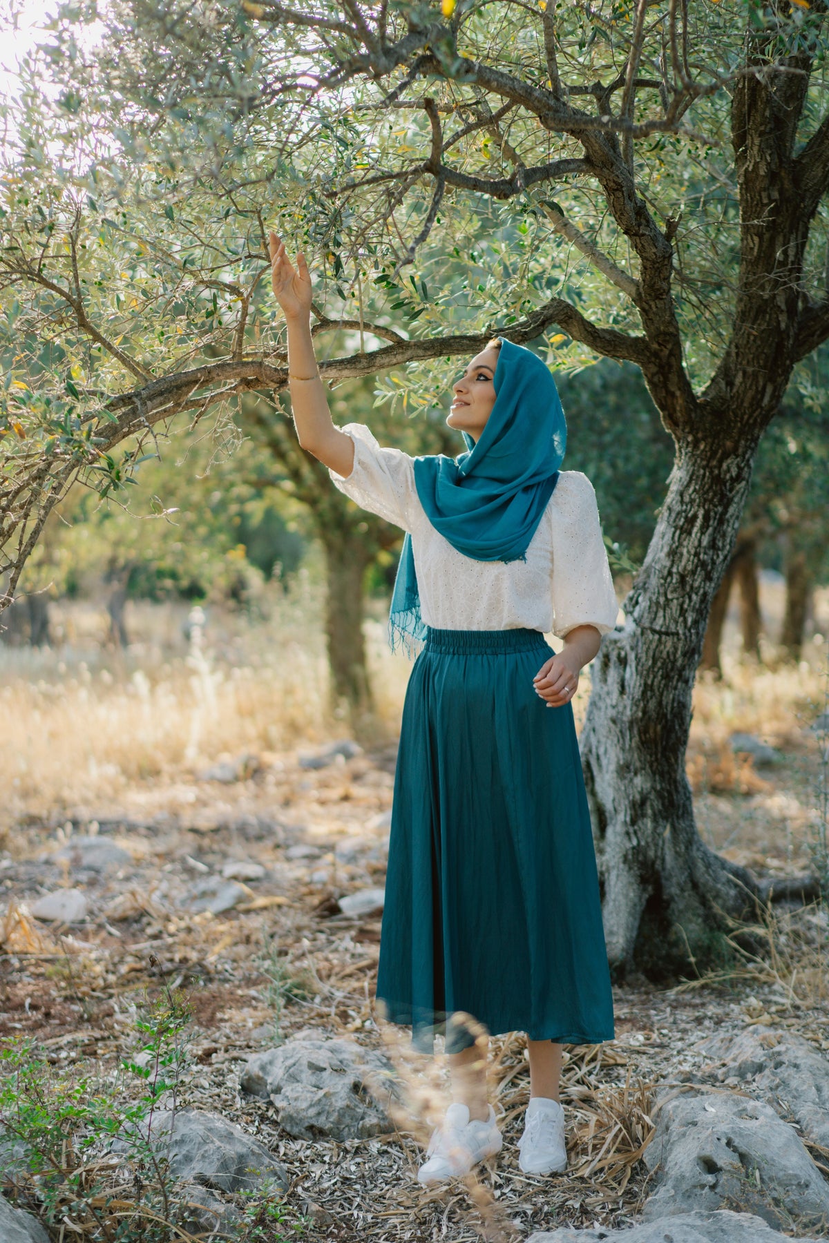 Muslim woman wearing a hijab, white blouse and long blue skirt outdoors, illustrating modest blue skirt and dress styling