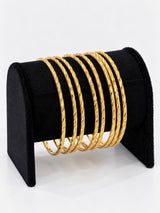 24K gold plated set of 8 textured bangles on black jewellery stand