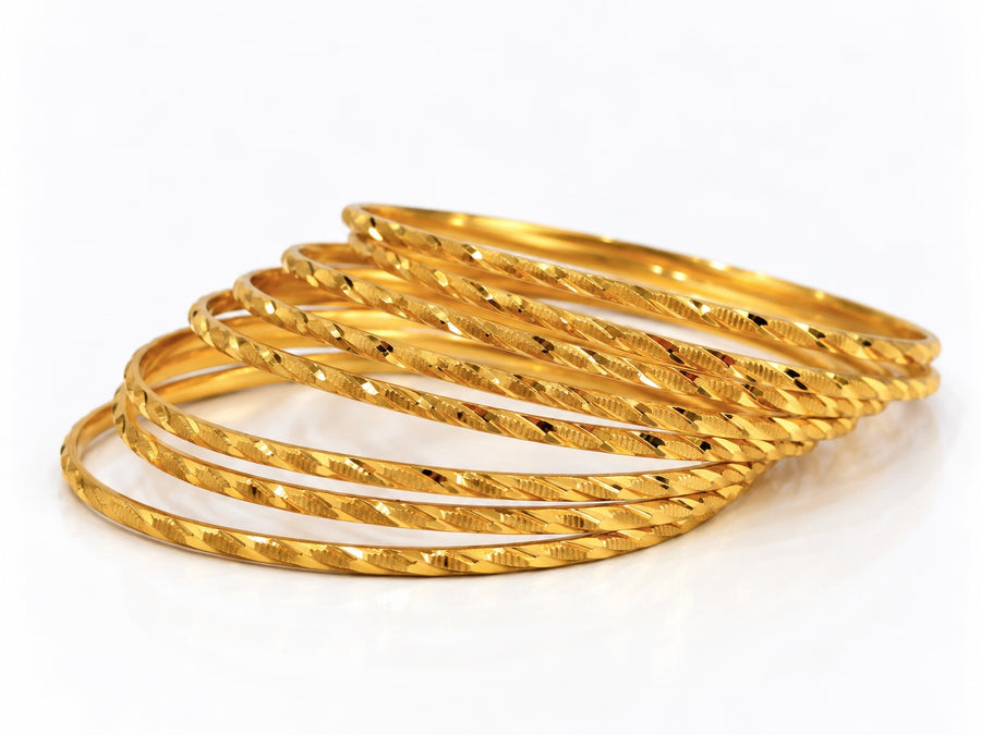 24K gold plated set of 8 textured bangles on white background