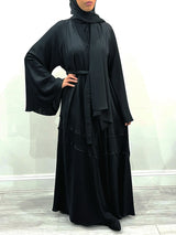 Amani's black umbrella-cut open abaya showing the wide flared hem